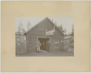 Two men stand outside W.W. Boyd's Blacksmith shop